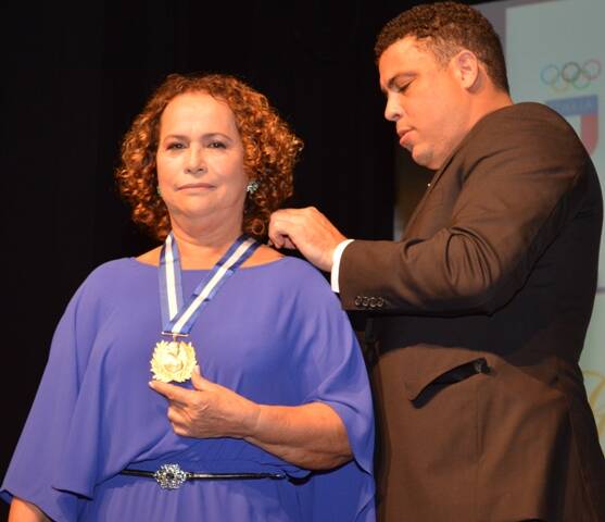 D. Sonia recebe ajuda do filho para colocar a medalha- Foto Rodrigo Mesquita