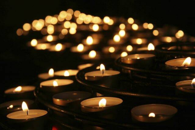 Charity. Lignting of Praying candles in a temple.